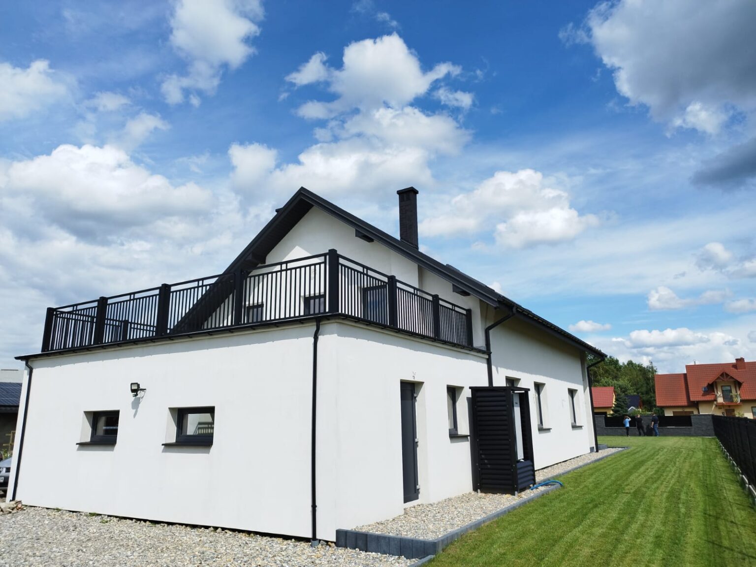 biały budynek z białą balustradą aluminiową, w tle niebo