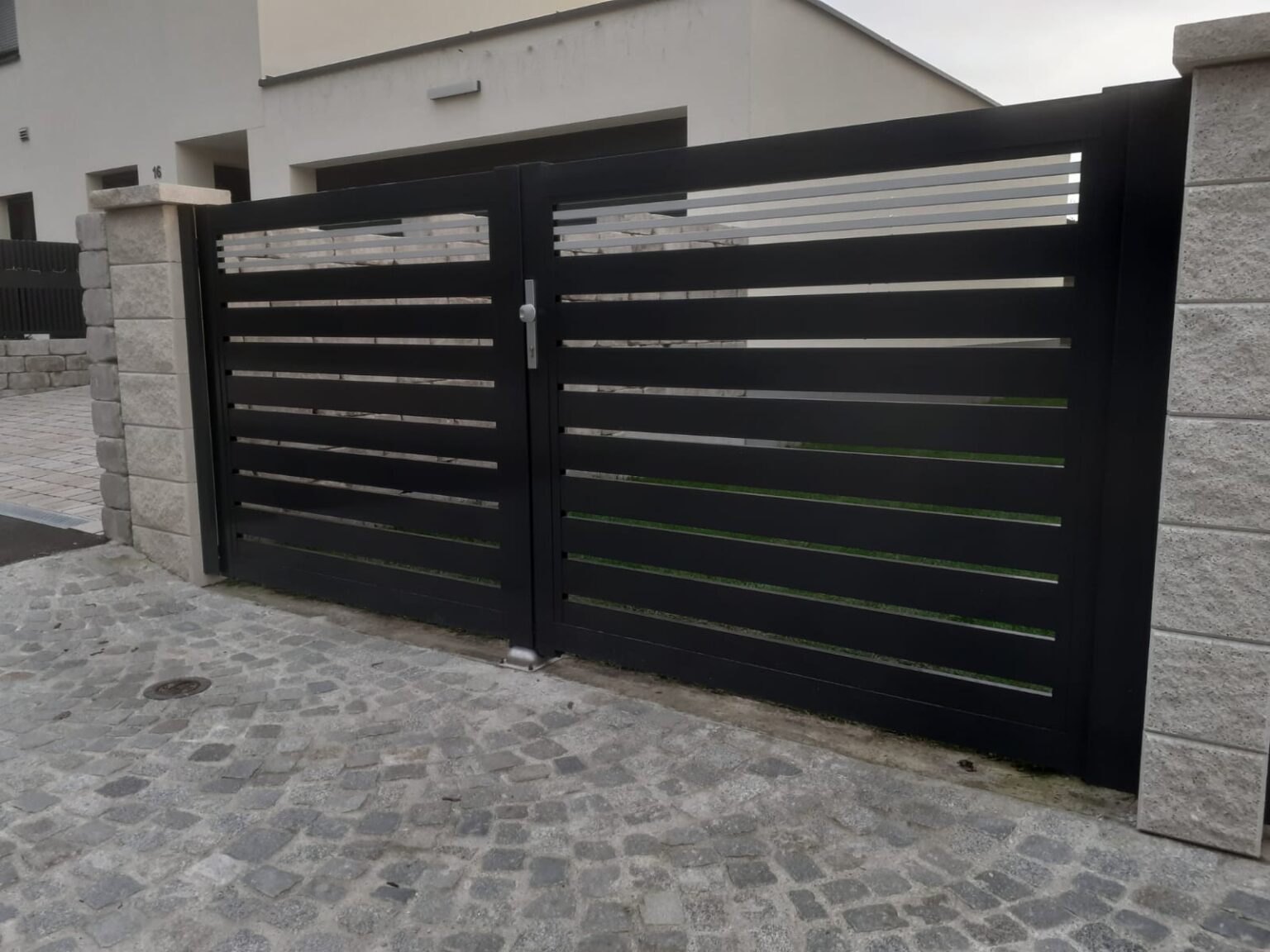 brama aluminiowa dwuskrzydłowa friz, widok od frontu, w tle biały budynek