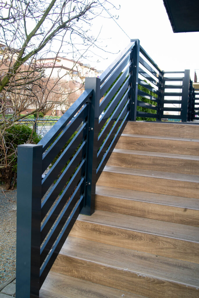 aluminiowa balustrada na schody wejściowe, w tle drzewa